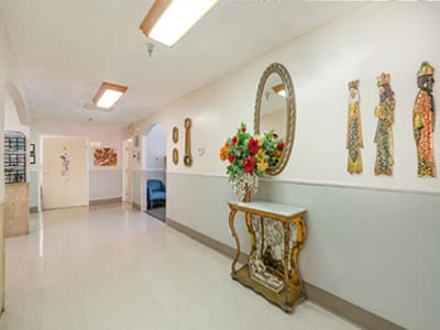 A bright hallway with decorative art and floral arrangements