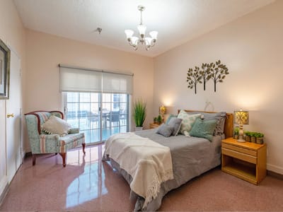 Well-decorated resident room with twin bed and plant