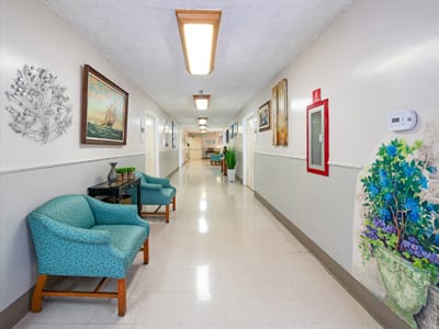 A well-lit hallway with chairs and artwork