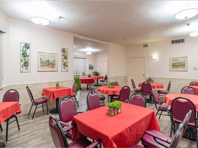 Dining room with red tablecloths and chairs