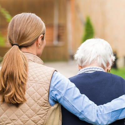 A caregiver assisting a senior outdoors