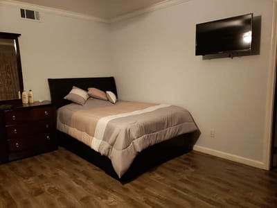 A neatly arranged resident room with a bed and TV