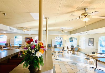 Bright dining area with tables and flower arrangement