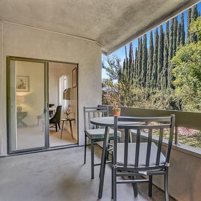 Outdoor balcony with seating and trees in view