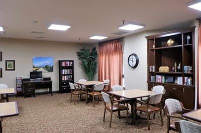 Interior view of a common area with tables and bookshelves