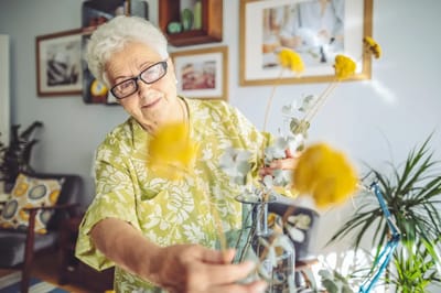 Resident arranging flowers in a bright common area