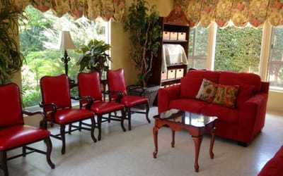Bright lounge area with red chairs and plants