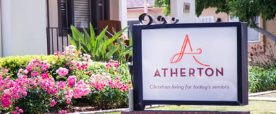 Exterior sign for Atherton Baptist Homes with flowers