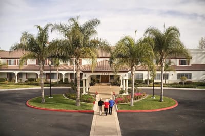 Residents walking towards the entrance of an assisted living facility