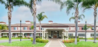 Exterior view of a senior living facility with palm trees
