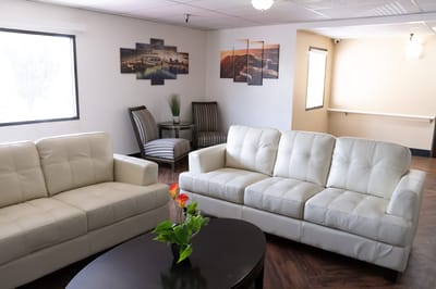Bright common area with white sofas and artwork