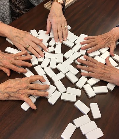 Residents playing dominos at a table