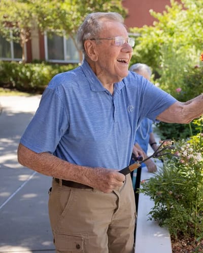 Elderly man gardening in a vibrant outdoor space