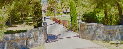 Entrance gate to Whispering Pines Inn surrounded by greenery