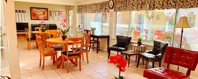 Bright common area with tables and chairs, flowers