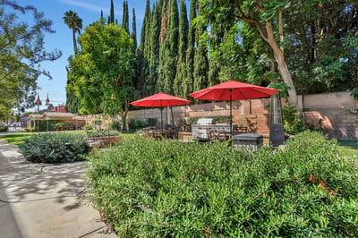 Well-maintained garden area with patio umbrellas