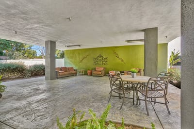 Covered outdoor seating area with greenery