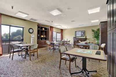 Bright common area with tables and chairs for activities