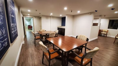 Common area with tables and chairs in a senior living facility