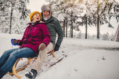 Couple enjoying a winter outing on a sled