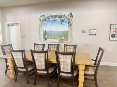 Dining area with a large table and decorative mural