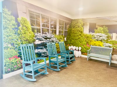 Interior common area with blue rocking chairs and green wall