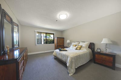 A private resident room with a bed and dresser