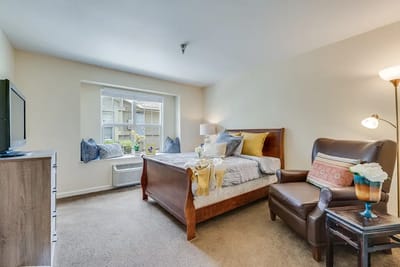 Cozy private resident room with a bed and chair