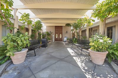 Outdoor seating area with plants and entrance