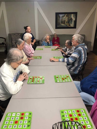 Residents engaged in a bingo game in an activity room