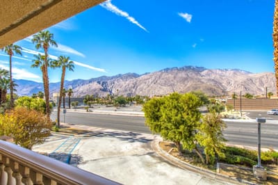 View of the mountains with palm trees and a parking area