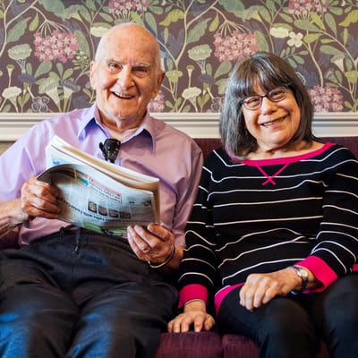 Two residents sitting together on a couch, smiling.