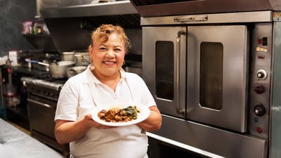 Staff member presenting a dish in the kitchen