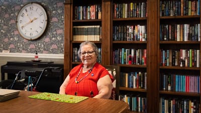 Resident sitting at a table in a cozy library area
