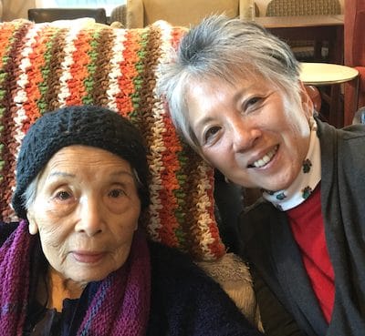 A resident and staff member smiling together