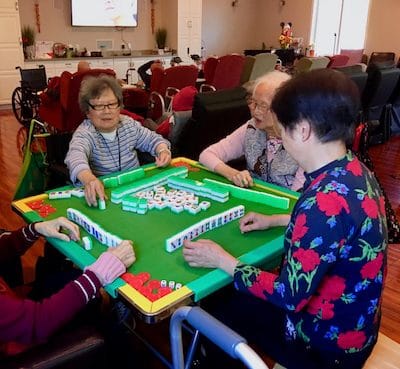 Residents enjoying a game of mahjong in a common area