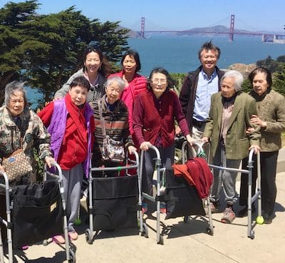 Residents enjoying an outdoor group photo with a scenic background