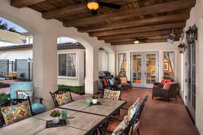 Outdoor seating area with chairs and tables under a pergola