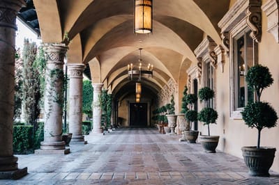 Elegant hallway with arches and potted plants