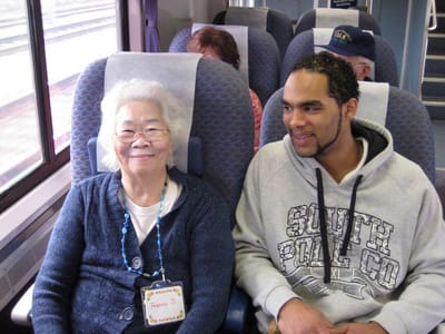 Two individuals smiling together on a train