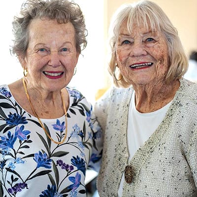 Two smiling elderly women at an event