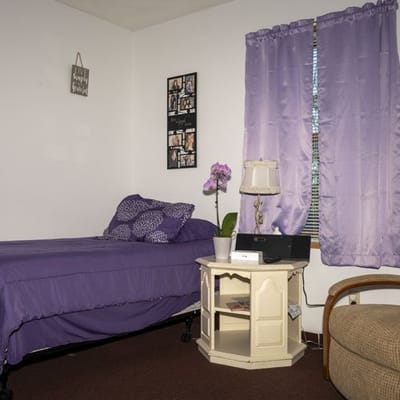 Cozy resident room with purple decor and furniture