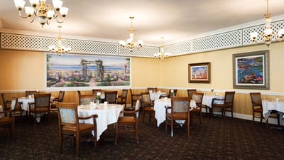 Elegant dining room with white tablecloths and artwork
