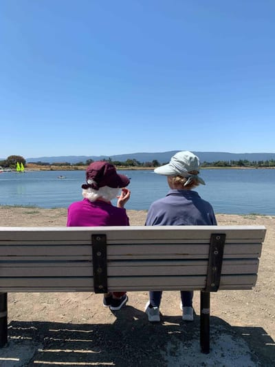Two residents enjoying a view by the water