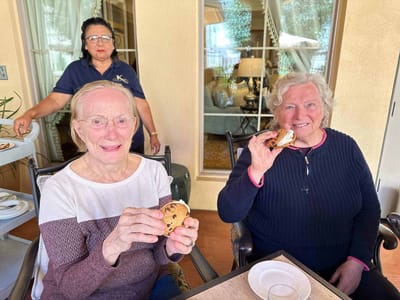 Two residents enjoying cookies in a common area