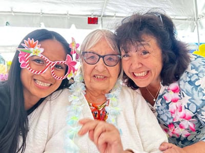 Residents and staff celebrating with leis and decorations