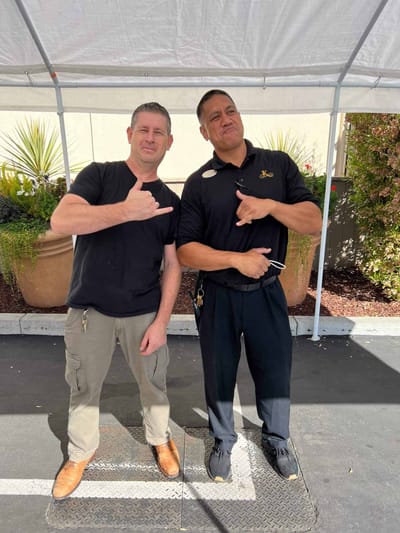 Two staff members posing outdoors