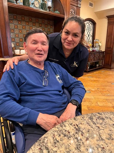 Resident and staff member smiling in a common area