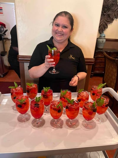 Staff serving colorful drinks on a tray