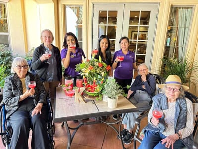 Residents and staff celebrating with drinks in a social setting